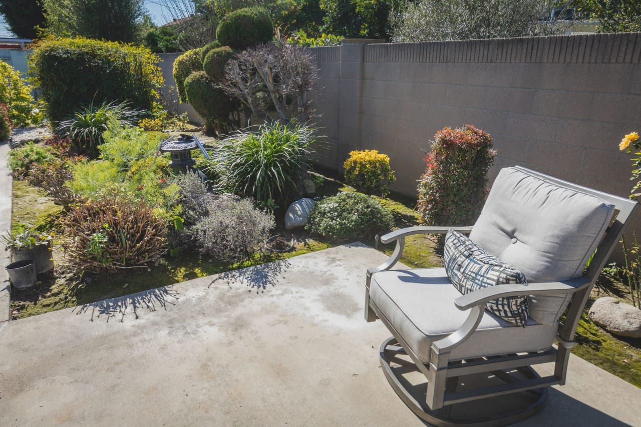 A cushioned patio chair beside a garden bed at the OC Revive campus.